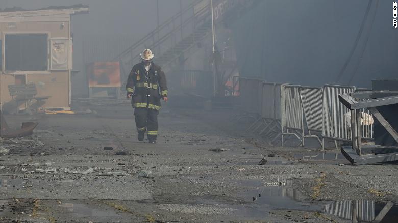 A fire official walks near the site of the Pier 45 fire on Saturday.