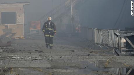 A fire official walks near the site of the Pier 45 fire on Saturday.