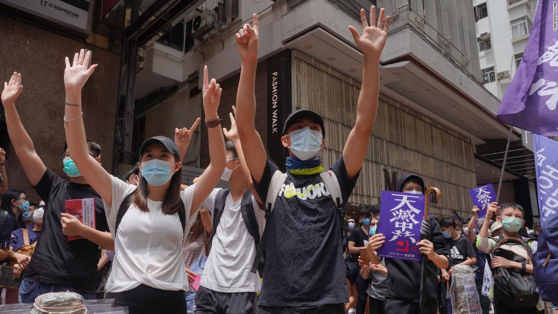 Protesters gesture with five fingers, signifying the &quot;Five demands - not one less&quot; as they march along a downtown street during a pro-democracy protest against Beijing&#39;s national security legislation in Hong Kong, Sunday, May 24, 2020. Hong Kong&#39;s pro-democracy camp has sharply criticised China&#39;s move to enact national security legislation in the semi-autonomous territory. They say it goes against the &quot;one country, two systems&quot; framework that promises the city freedoms not found on the mainland.