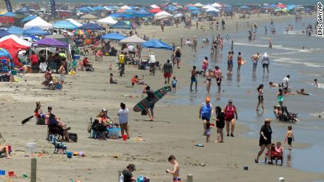 People gather on the beach for the Memorial Day weekend in Port Aransas, Texas, Saturday, May 23, 2020. Beachgoers are being urged to practice social distancing to guard against COVID-19. 