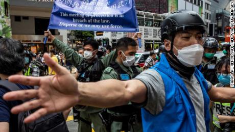 La policía insta a los manifestantes a favor de la democracia reunidos en el distrito de Causeway Bay de Hong Kong a irse el 24 de mayo de 2020, antes de las protestas planificadas contra una propuesta para promulgar nuevas leyes de seguridad en Hong Kong.