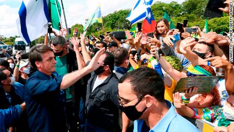 Brazil&#39;s President Jair Bolsonaro greets supporters upon arrival at Planalto Palace in Brasilia, on May 24.