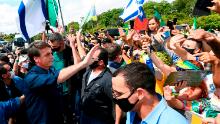 Brazil&#39;s President Jair Bolsonaro greets supporters upon arrival at Planalto Palace in Brasilia, on May 24.