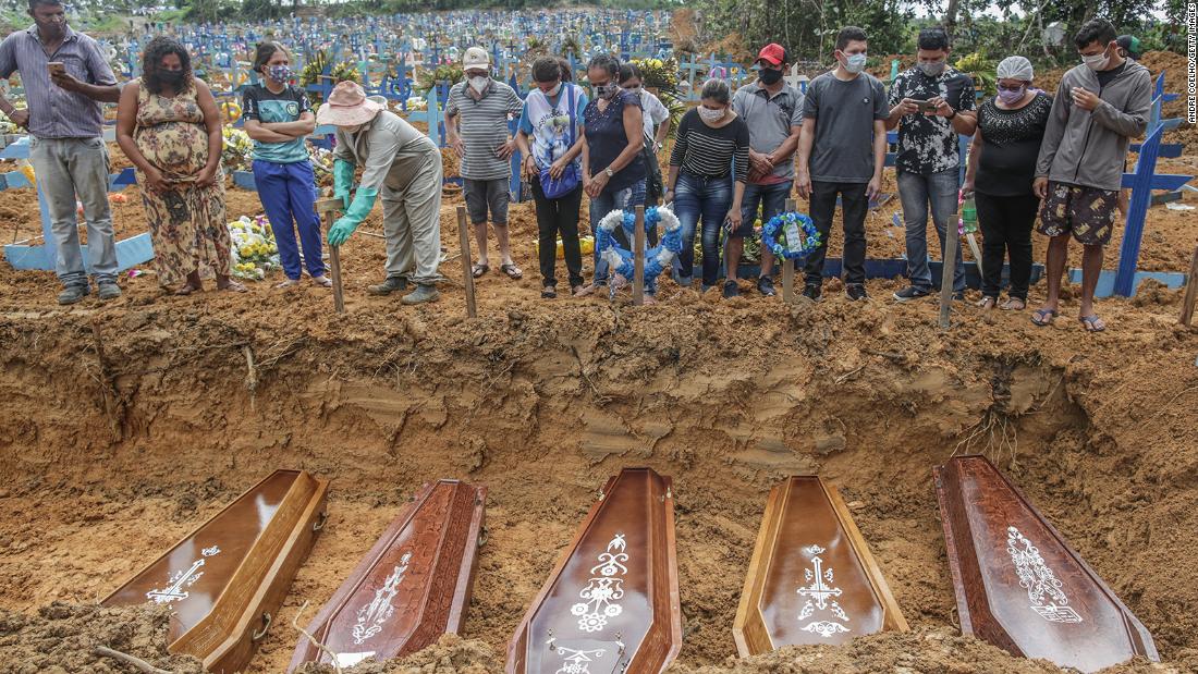 MANAUS, BRAZIL - MAY 19: People wearing protective masks observe to the graves with the remains of their relatives during a mass burial of coronavirus (COVID-19) pandemic victims at the Parque Taruma cemetery on May 19, 2020 in Manaus, Brazil. Brazil has over 260,000 confirmed cases and more than 17,000 deaths caused by coronavirus (COVID-19) pandemic. (Photo by Andre Coelho/Getty Images)