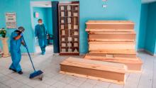 A worker sweeps the floor next to coffins for Covid-19 victims at El Angel cemetery, in Peru&#39;s capital, Lima, on May 21.