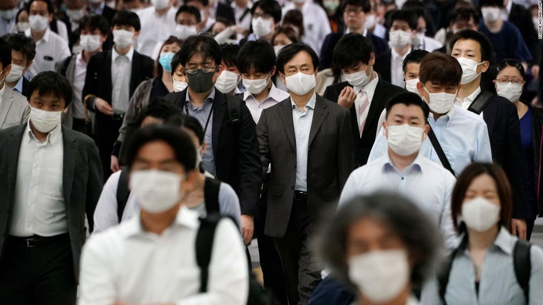 Commuters crowd a train station in Tokyo during the morning rush hour on May 26, 2020.