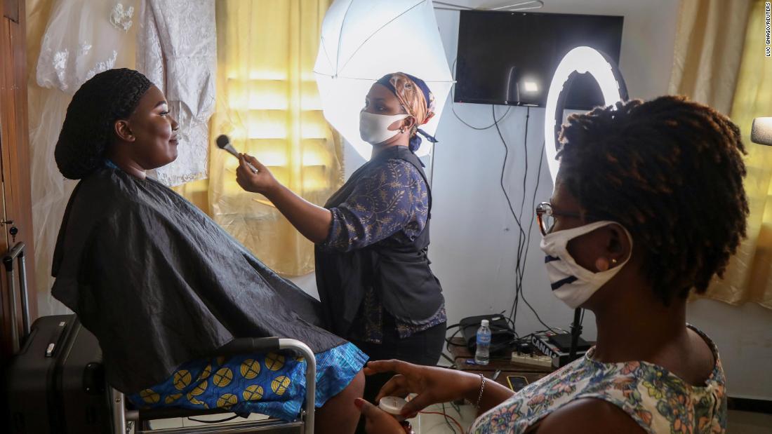 Make-up artists wear face masks while preparing Marie Andrea Offoumou for her wedding in Abidjan, Ivory Coast, on May 15.