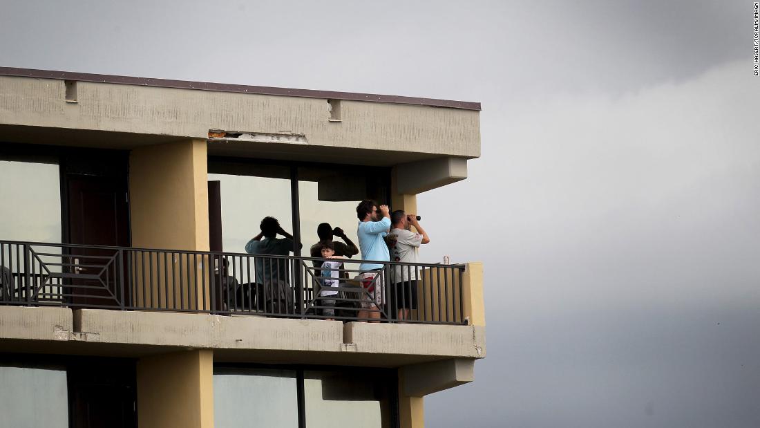 Spectators look out from a hotel balcony in Cocoa Beach, Florida.