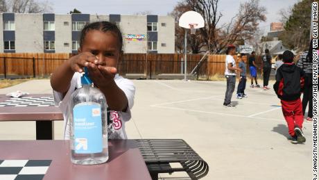 Four-year-old Messiah Guyton puts on hand sanitizer before eating his snack.