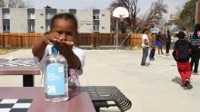 Four-year-old Messiah Guyton puts on hand sanitizer before eating his snack.