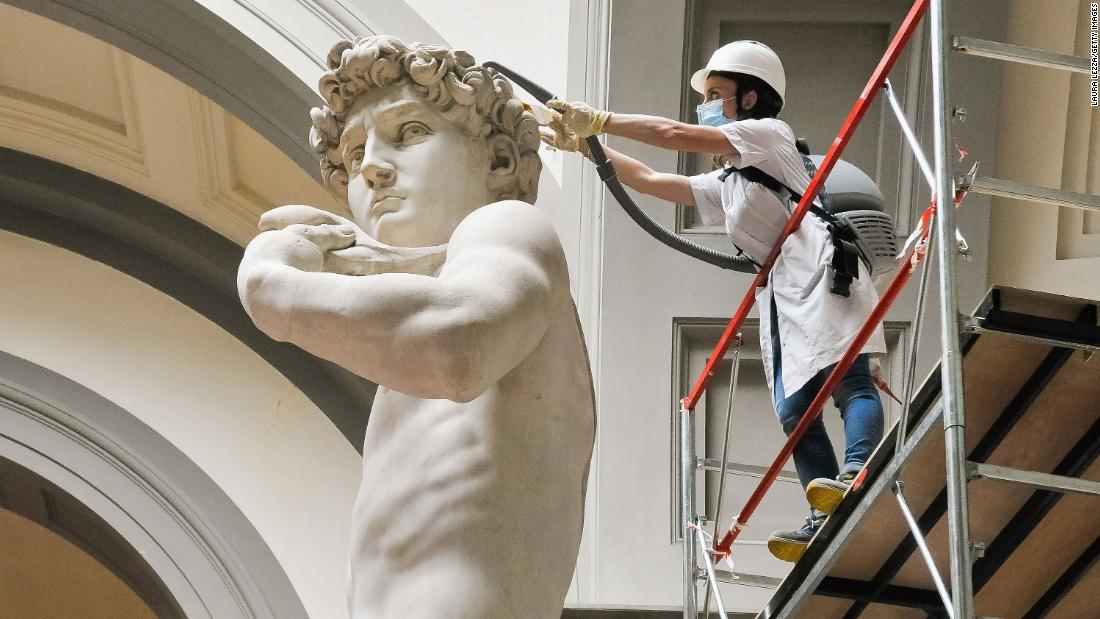 A restorer cleans Michelangelo&#39;s David statue on May 27 while preparing for the reopening of the Galleria dell&#39;Accademia in Florence, Italy.