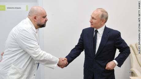 Russian President Vladimir Putin, right, shaking hands with Denis Protsenko, the head of a new hospital treating coronavirus patients in Moscow on March 24.