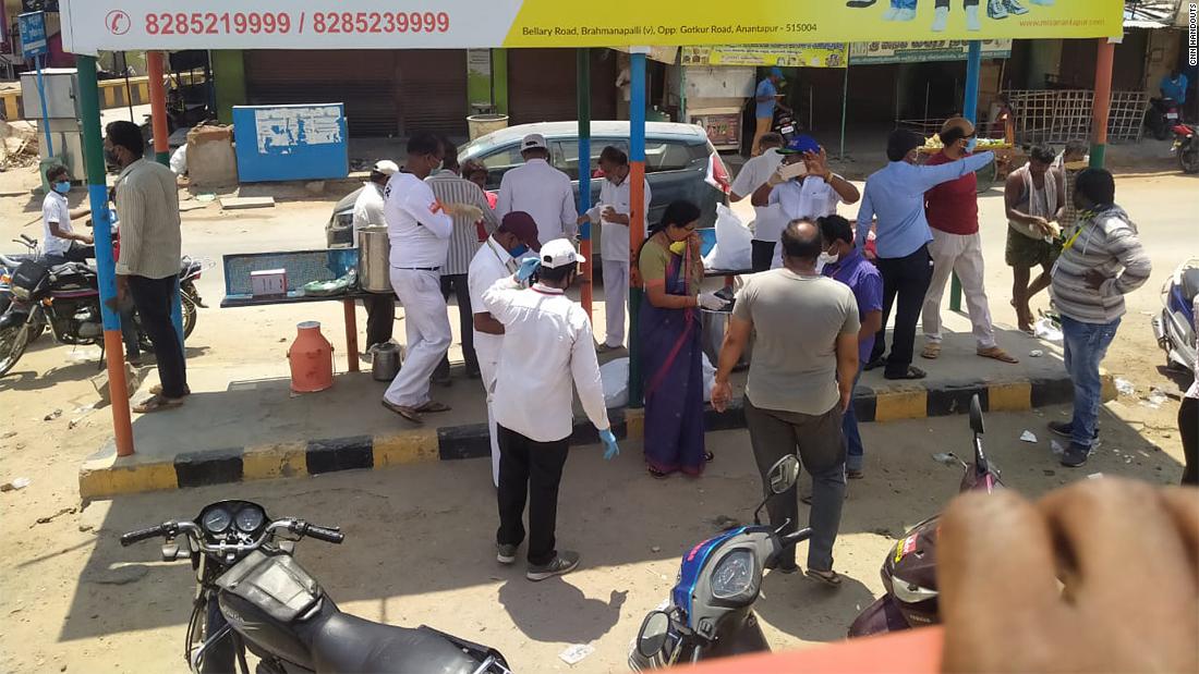 Volunteers distribute food to migrants on National Highway 44.