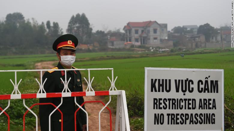 A Vietnamese People's Army officer stands next to a sign warning about the lockdown on the Son Loi commune in Vinh Phuc province on February 20.