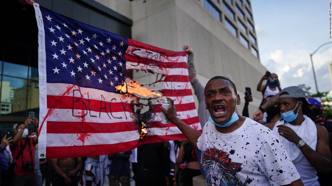 Protesters burn a flag outside the CNN Center in Atlanta on May 29.
