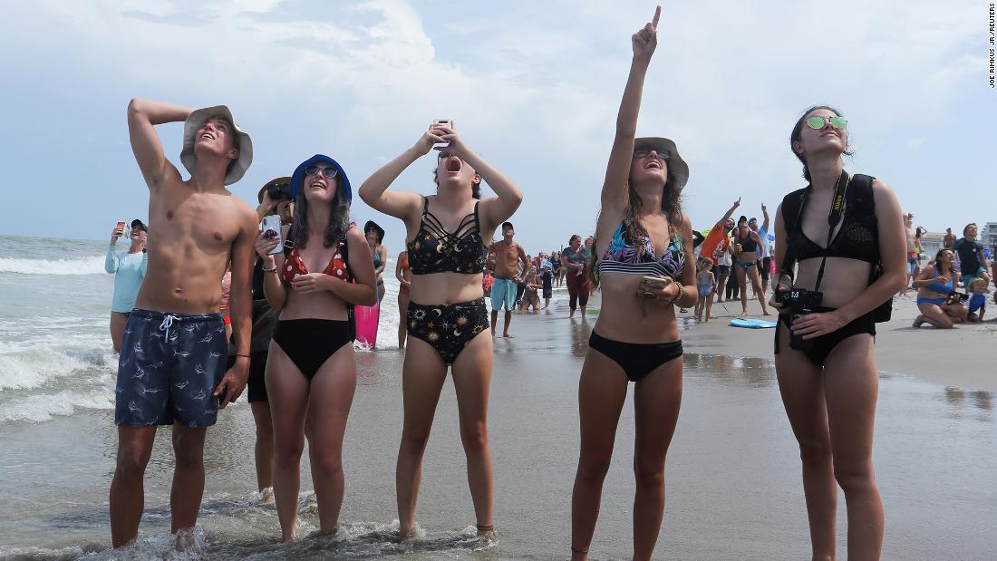 People watch the launch from a beach in Cape Canaveral.