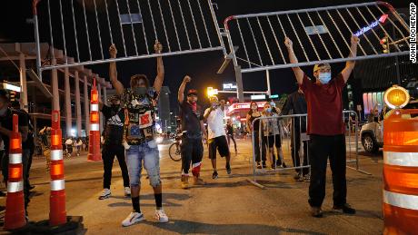 Protesters hold up metal gates as they build a barrier in a roadway on Saturday in Las Vegas.
