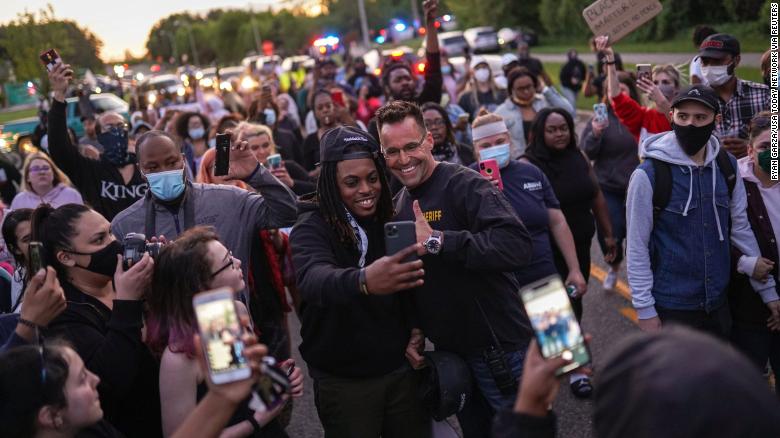 Johnie Franklin of Flint takes a selfie with Genesee County Sheriff Chris Swanson as he marches with protesters against police brutality and in memory of George Floyd on Saturday in Flint Township, Michigan.