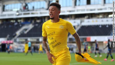 Jadon Sancho of Borussia Dortmund celebrates scoring his team&#39;s second goal of the game with a &#39;Justice for George Floyd&#39; t-shirt during 6-1 Bundesliga win over SC Paderborn.