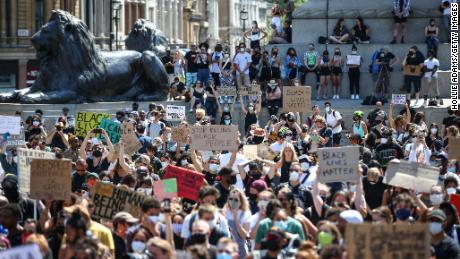 People hold placards as they join a Black Lives Matter march at Trafalgar Square in London on Sunday. 