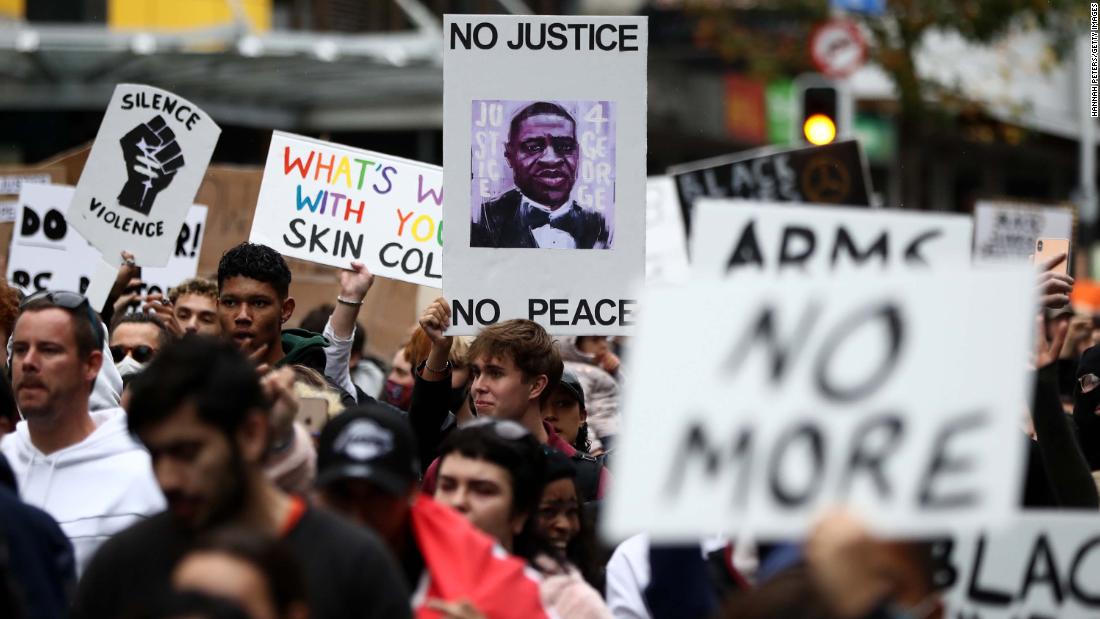 Protestors march down Queen Street in Auckland, New Zealand on Monday.