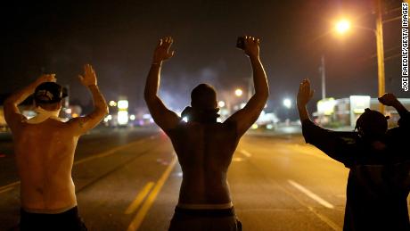 Demonstrators raise their arms as they protest the shooting death of Michael Brown on August 17, 2014 in Ferguson, Missouri. 