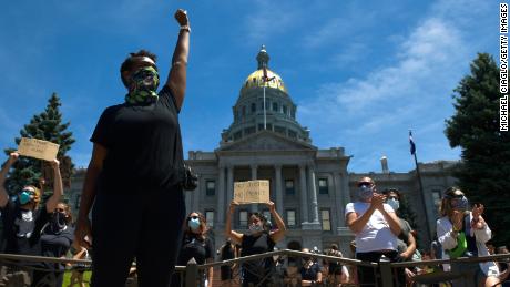 A woman at the state Capitol in Denver raises her fist during the fifth consecutive day of protests.