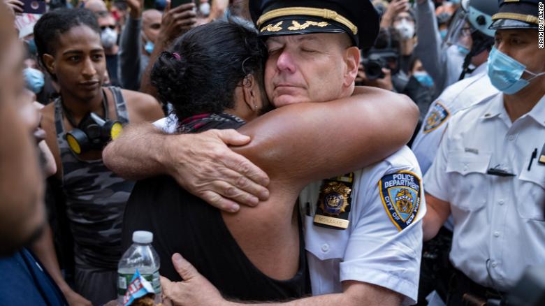 Chief of Department of the New York City Police, Terence Monahan, hugs an activist.