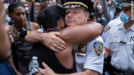 Chief of Department of the New York City Police, Terence Monahan, hugs an activist.