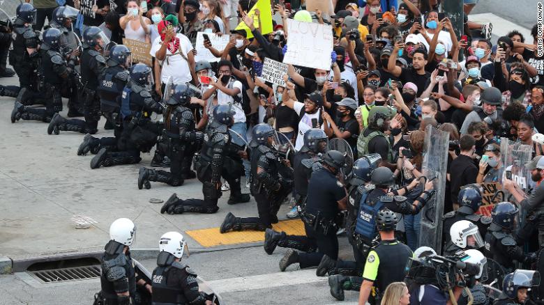 Atlanta officers take a knee before protesters.