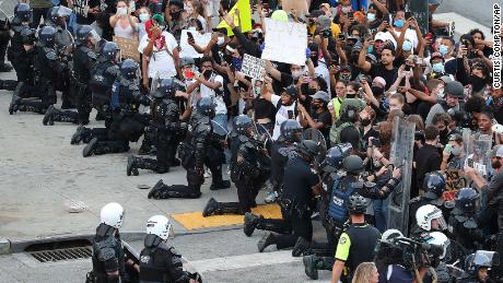 Atlanta officers take a knee before protesters.