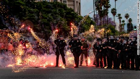 A firecracker thrown by a protester explodes at the feet of police during a demonstration against the death of George Floyd Monday in Riverside, California.