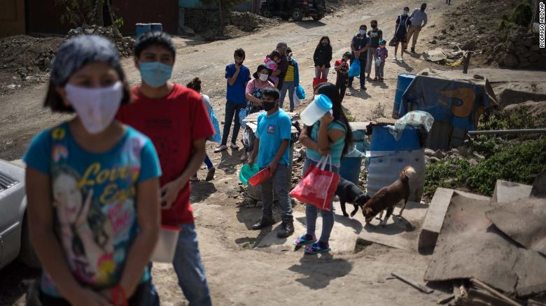 Residents stand in a line at a soup kitchen on the outskirts of Lima, Peru, on Friday, May 29.