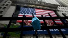 A face mask is seen in front of the New York Stock Exchange (NYSE) on May 26, 2020 at Wall Street in New York City. - Global stock markets climbed Monday, buoyed by the prospect of further easing of coronavirus lockdowns despite sharp increases in case rates in some countries such as Brazil. Over the weekend, US President Donald Trump imposed travel limits on Brazil, now the second worst affected country after the United States, reminding markets that while the coronavirus outlook is better, the crisis is far from over. (Photo by Johannes EISELE / AFP) (Photo by JOHANNES EISELE/AFP via Getty Images)