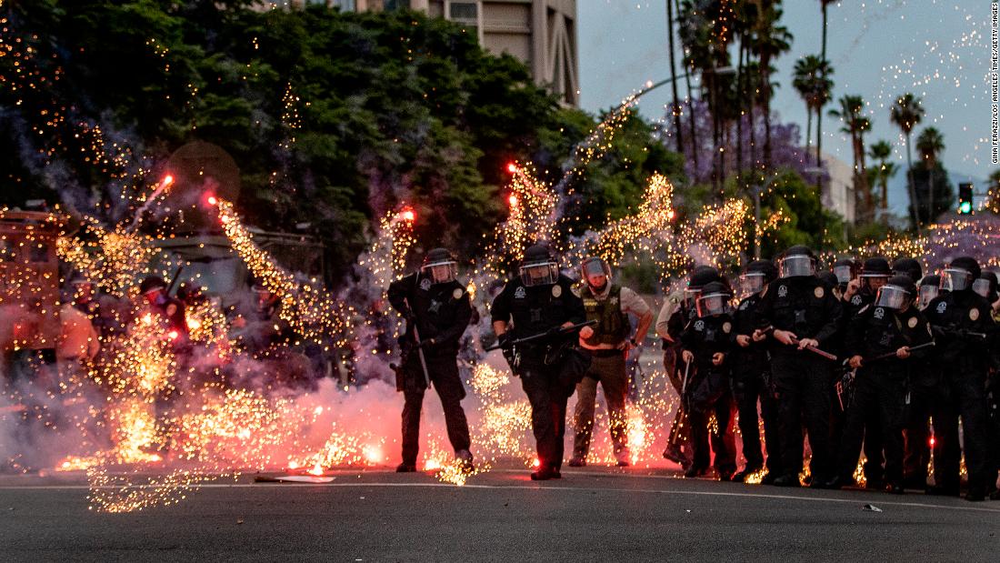 A firework thrown by a protester explodes at the feet of police in Riverside, California, on June 1.