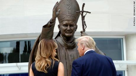 President Trump and first lady Melania Trump view a statue of Pope John Paul II on Tuesday in Washington.