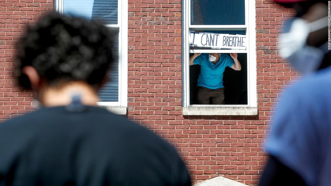 A resident of Clarksville, Tennessee, holds up a sign that says &quot;I can&#39;t breathe&quot; across the street from protesters on June 2.