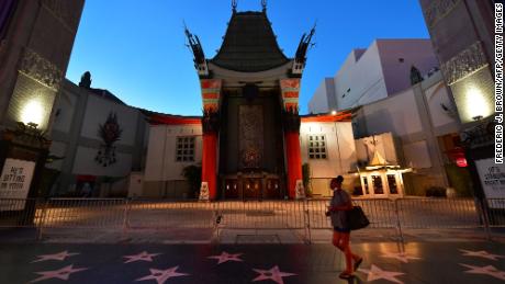 A woman walks past the closed courtyard in front of the TCL Chinese Theater, famed for the hand and foot prints of movie stars.