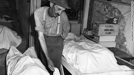 Coroner W.T. Brown places a sheet over the body of one of four Moore&#39;s Ford lynching victims in 1946. 