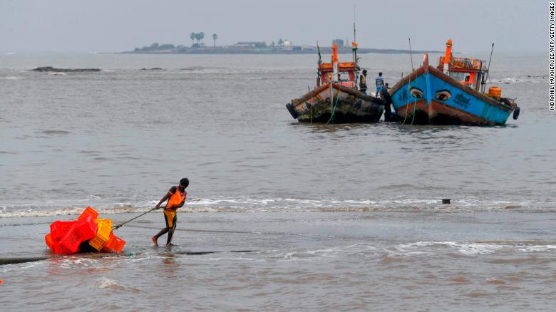 A fisherman pulls a handcart filled with crates inland ahead of a cyclonic storm in the north western coast of Mumbai on June 2.