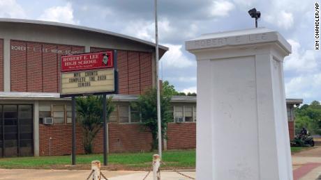 Un pedestal con una estatua de Robert E. Lee está vacío frente a una escuela secundaria que lleva el nombre del general confederado.