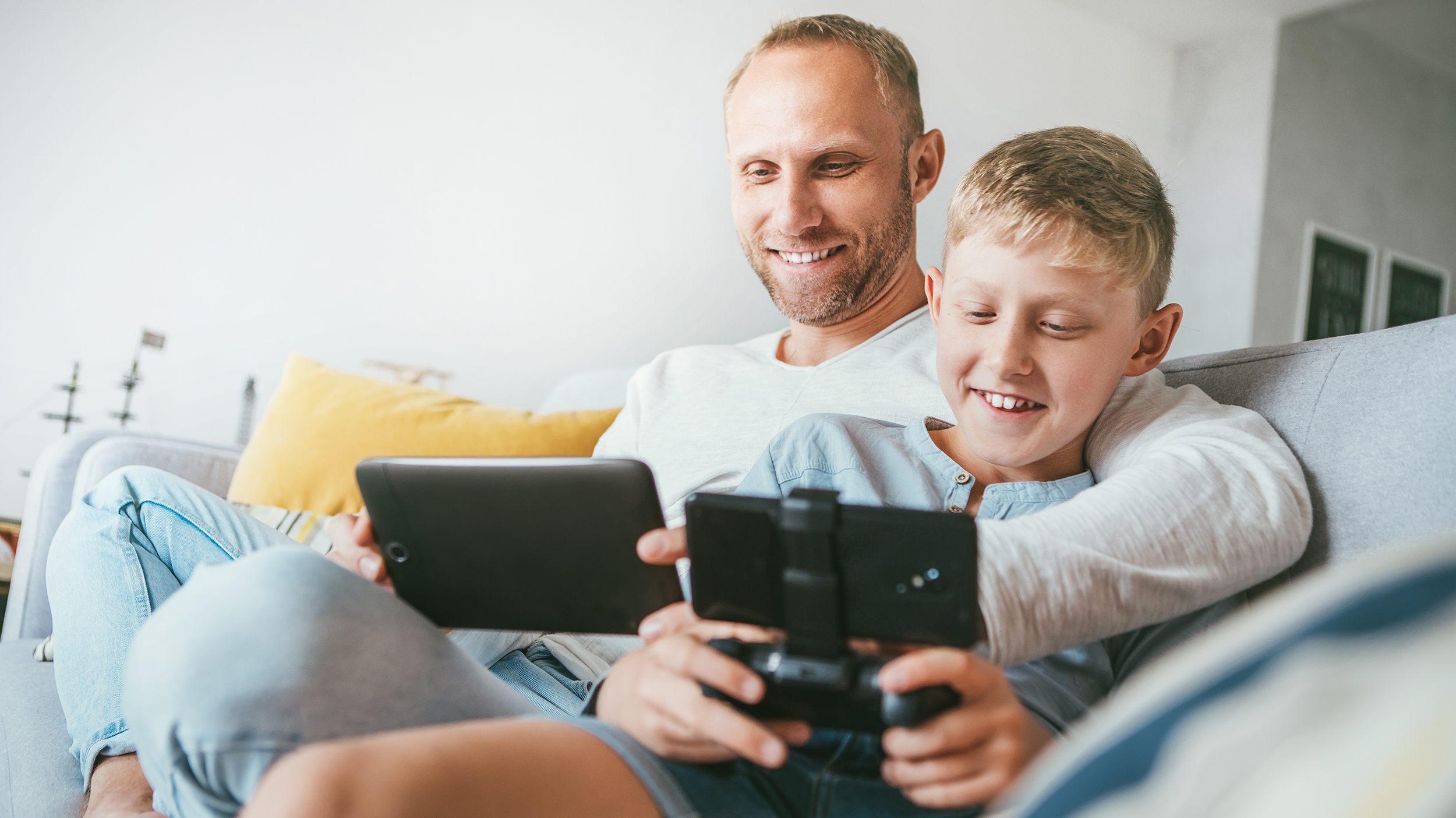 Dad likes playing. Папа играет в телефон. Папа играет с сыном. Отец и сын сидят перед телевизором. Отец играет с сыном геймпад.