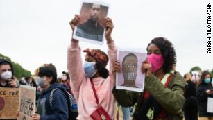 Demonstrators display pictures of George Floyd.