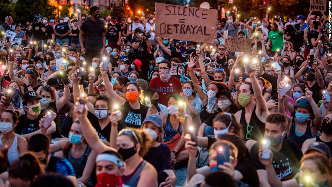 Protesters hold up their phones during a demonstration outside the White House on June 3.