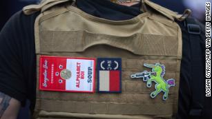 A member of the Boogaloo Bois walks next to protesters demonstrating outside Charlotte Mecklenburg Police Department Metro Division 2 just outside of downtown Charlotte, North Carolina, on May 29, 2020.