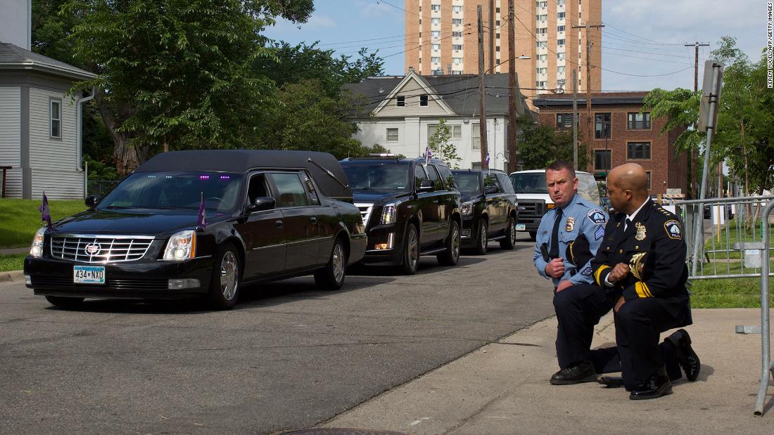 Minneapolis Police Chief Medaria Arradondo, right, kneels with another officer as Floyd&#39;s body passes by.