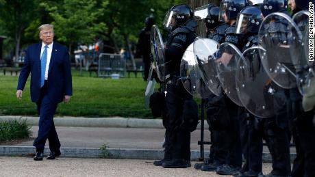 President Donald Trump walks past police in Lafayette Park after he visited outside St. John&#39;s Church across from the White House Monday, June 1, 2020, in Washington. Part of the church was set on fire during protests on Sunday night. 