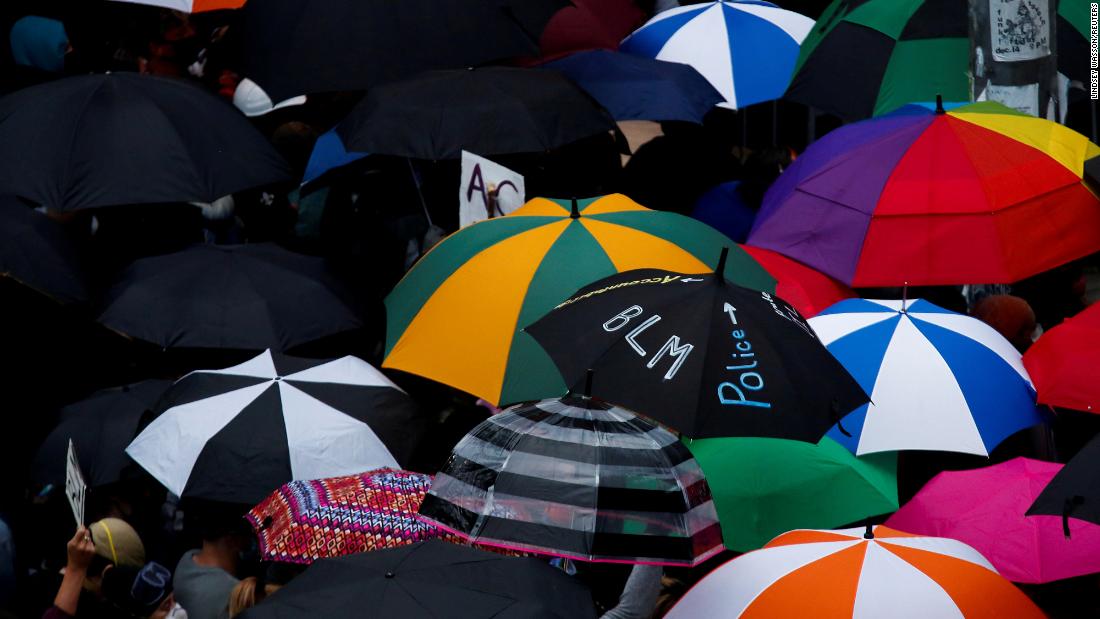 Protesters use umbrellas during a protest in Seattle on June 3.