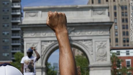 A demonstrator raises his fist in Washington square protesting the death of George Floyd, who died in police custody, on June 3, 2020 in New York. - Derek Chauvin, the white Minneapolis police officer who kneeled on the neck of George Floyd, a black man who later died, will now be charged with second-degree murder, and his three colleagues will also face charges, court documents revealed on June 3. The May 25 death of George Floyd -- who had been accused of trying to buy cigarettes with a counterfeit bill -- has ignited protests across the United States over systemic racism and police brutality. (Photo by Timothy A. Clary/AFP/Getty Images)