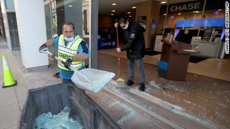 Clean up crews at a Chase Bank branch remove shattered glass early Sunday morning.